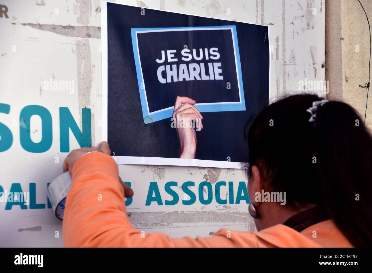 Eine Frau hängt ein Plakat mit der Aufschrift "je suis Charlie" auf.Fast hundert Medien, Zeitungen, Zeitschriften, Fernsehsender und Radiosender rufen die Franzosen auf, sich für die Meinungsfreiheit zu mobilisieren, um Charlie Hebdo zu unterstützen, Das seit der Wiederveröffentlichung von Mohammed-Karikaturen Gegenstand neuer Drohungen war. Der laufende Prozess des Angriffs auf die Zeitung, bei dem am 7. Januar 2015 12 Menschen ums Leben kamen, wird bis zum 10. November 2020 stattfinden. Stockfoto