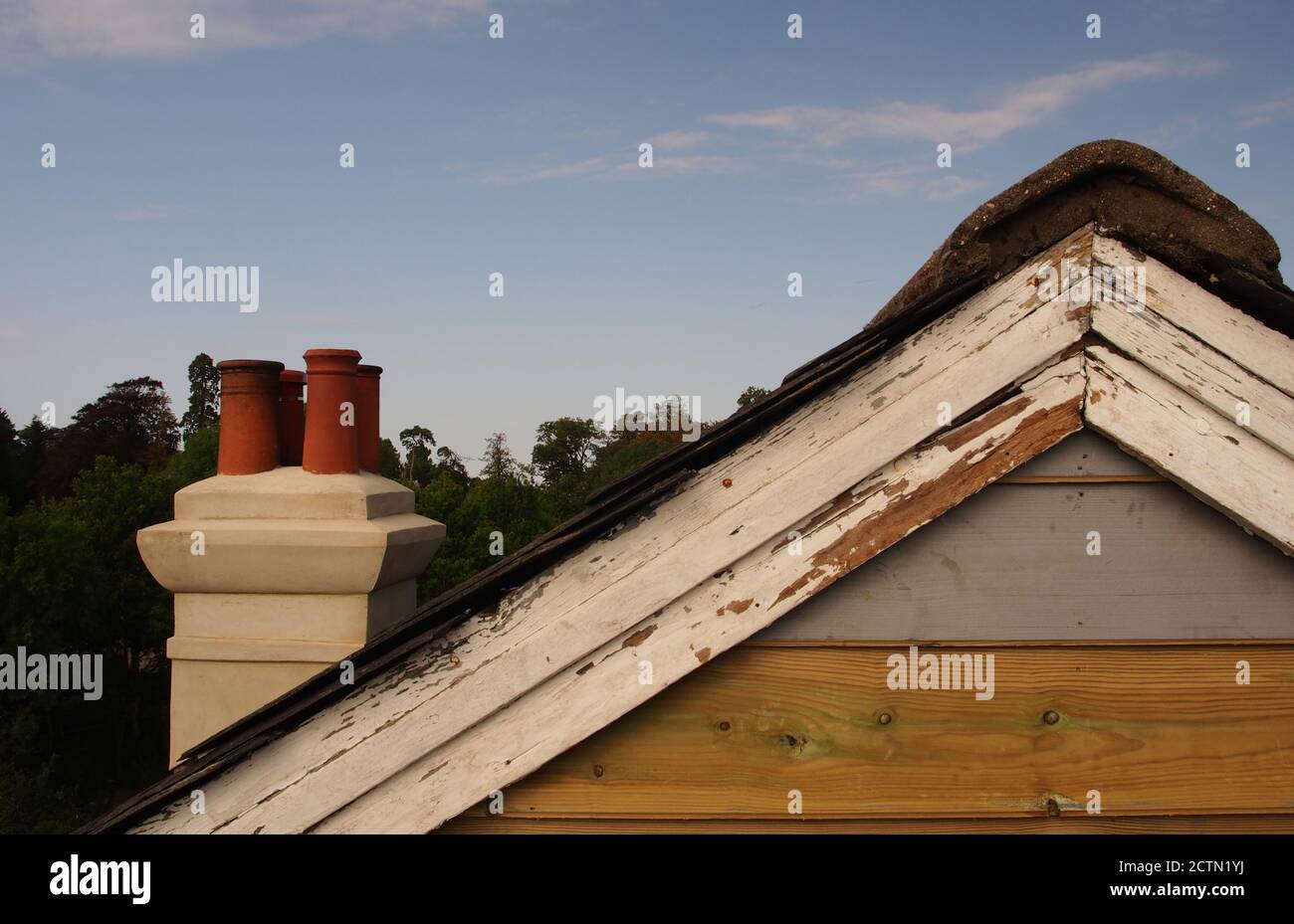 Blick vom Gerüst auf das reparierte Giebelende eines alten Holzhauses mit Schieferdach, das noch lackiert werden muss, plus alte Lastkahn-Bretter Stockfoto