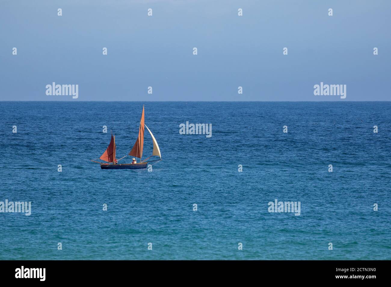 Traditionelle Segeljolle oder Klinker im Meer vor St. Ives, Cornwall, England, August Stockfoto