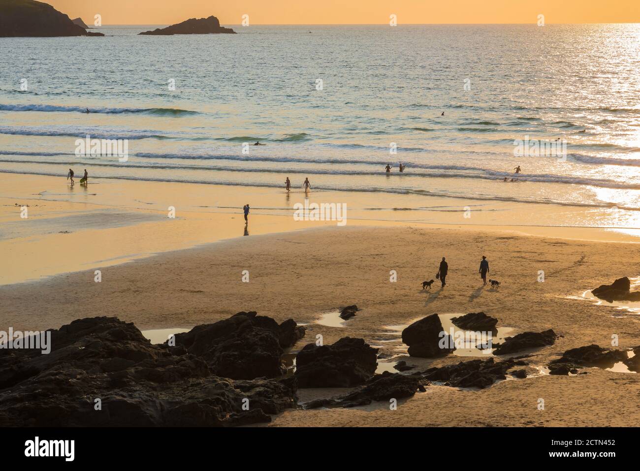 Cornwall England Beach, Blick bei Sonnenuntergang auf Menschen, die am Fistral Beach in der Nähe von Newquay in Cornwall, Südwesten Englands, Großbritannien, spazieren gehen Stockfoto