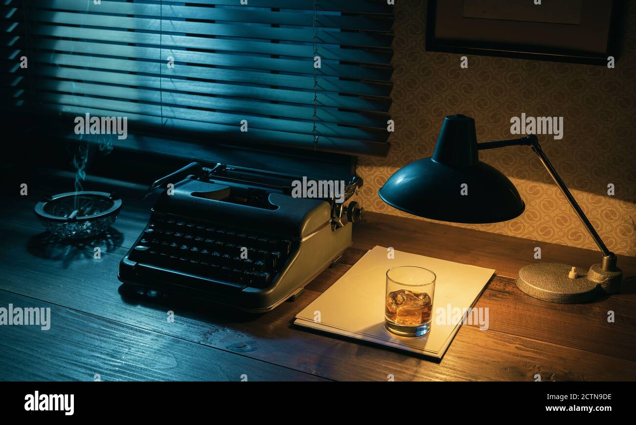 Vintage Film Noir Stil Schreibtischplatte mit Schreibmaschine und ein Glas Whiskey, Kreativität und Inspiration Konzept Stockfoto
