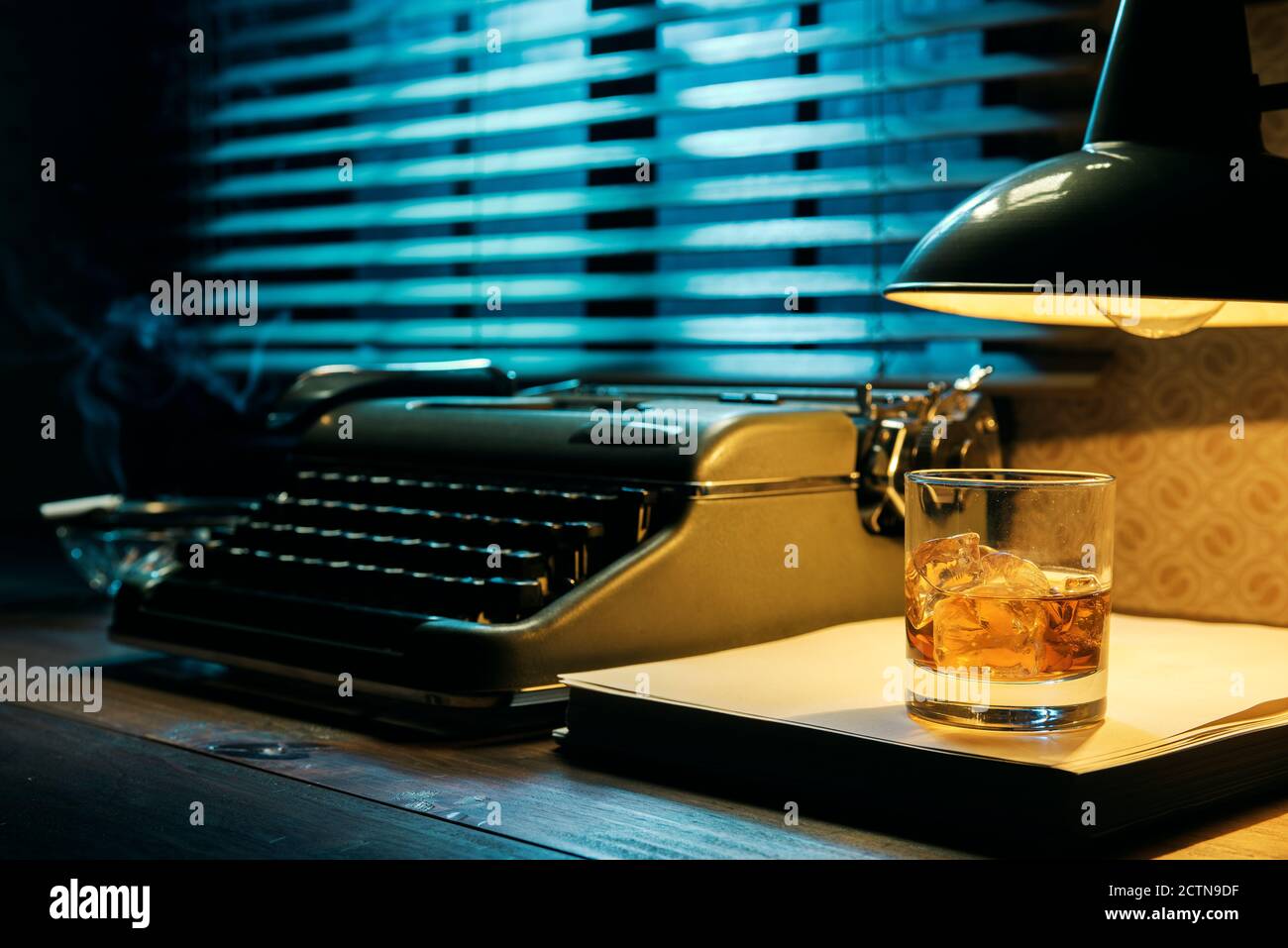 Vintage Film Noir Stil Schreibtischplatte mit Schreibmaschine und ein Glas Whiskey, Kreativität und Inspiration Konzept Stockfoto