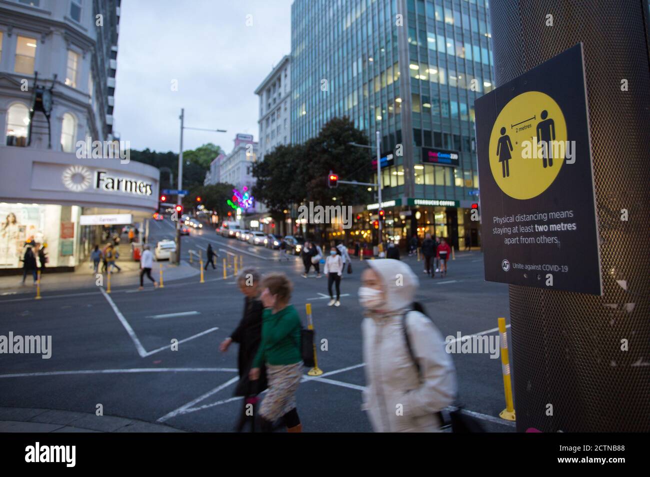 Auckland, Neuseeland. September 2020. Die Menschen gehen an einem Schild vorbei, das die Menschen daran erinnert, physische Distanz in Auckland, Neuseeland, 24. September 2020, zu halten. Auckland lockerte die Beschränkungen für Versammlungen, indem es von COVID-19 Alarmstufe 2.5 auf 2 abstieg, was bedeutet, dass die Sammelbeschränkungen von 10 auf 100 Personen gelockert werden. Quelle: Wilson/Xinhua/Alamy Live News Stockfoto