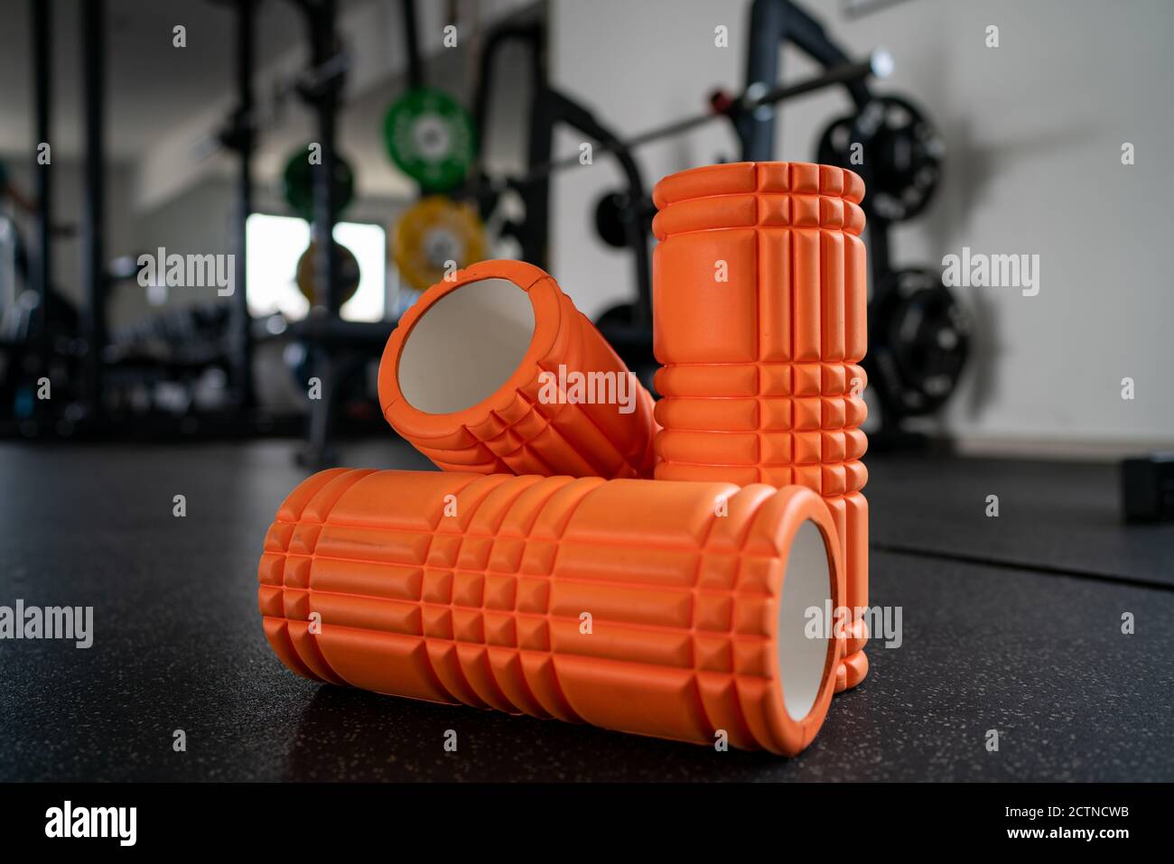 Drei Faszienrollen vor den Fitnessgeräten Stockfoto