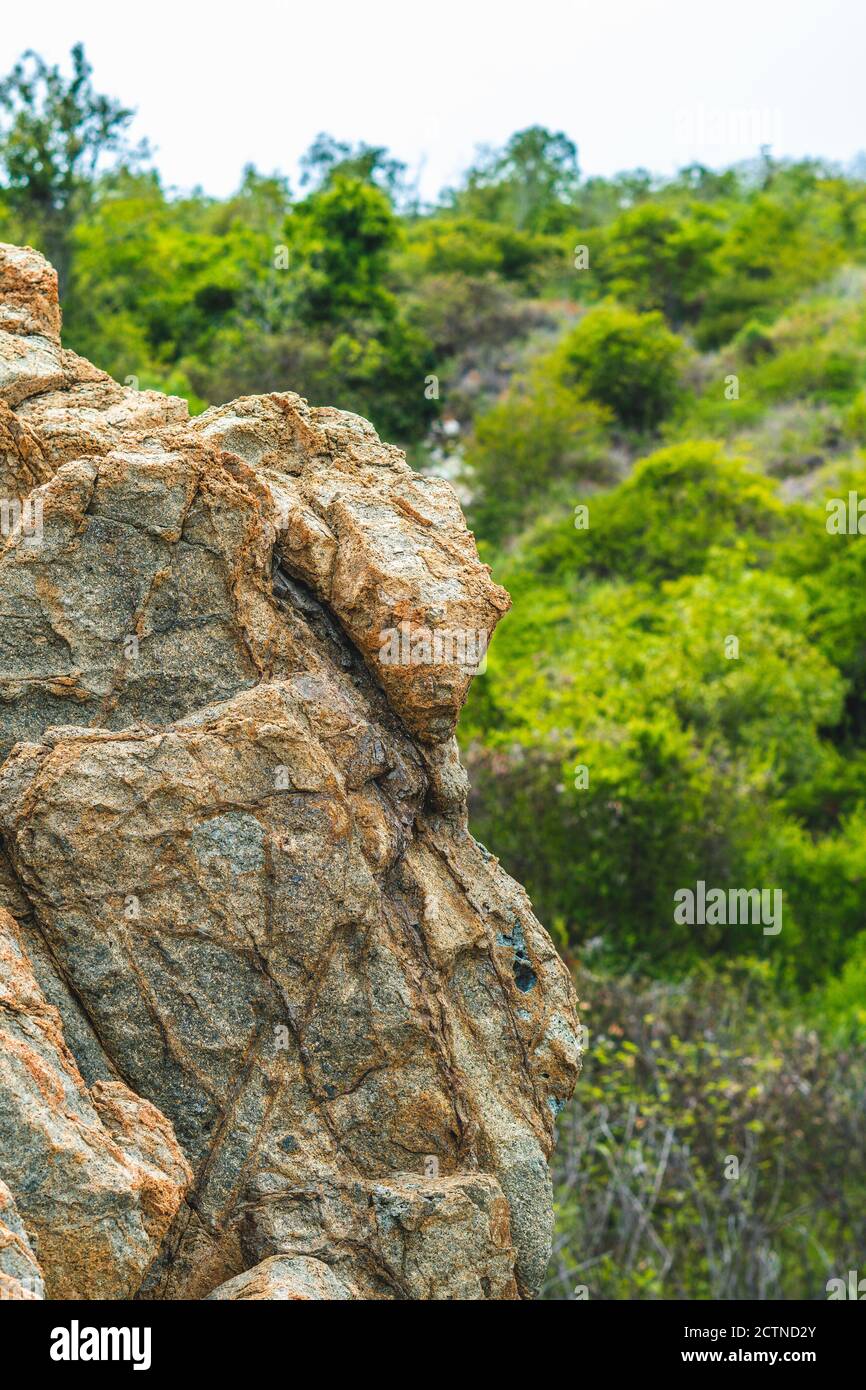 Schöne natürliche Sommer Komposition Wahrzeichen Hintergrund. Hell lebhaft orange braun gelb Stein Felsen schäbig Klippe Risse Textur Berge. Konzept Stockfoto