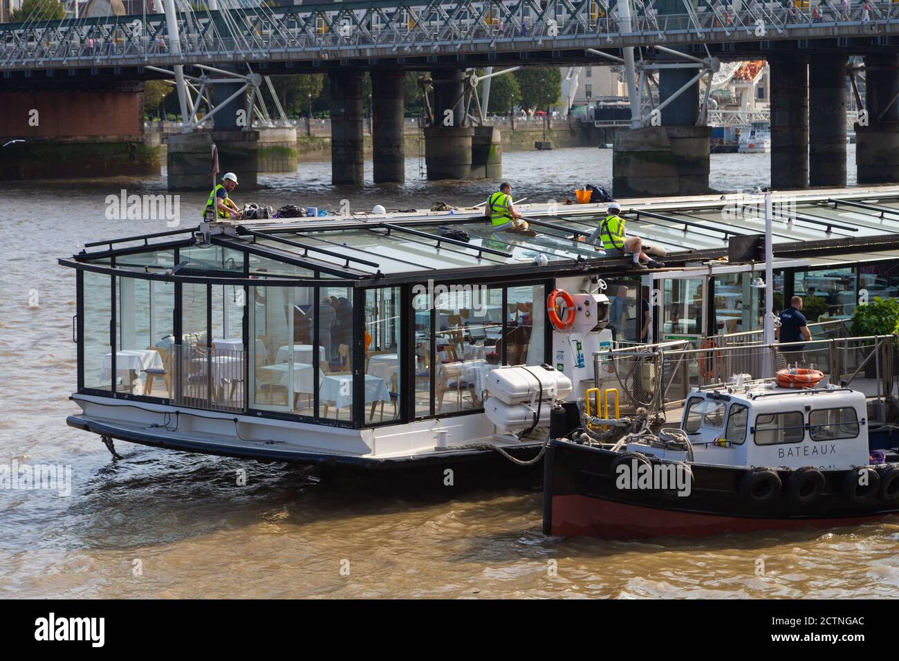 Arbeiter auf der themse Reparatur Bootsdach, Sicherheitsausrüstung, london, großbritannien Stockfoto