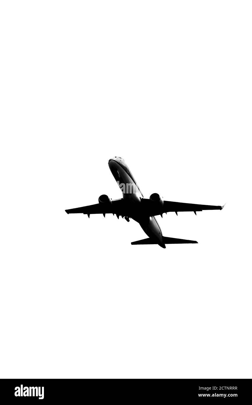 Silhouette eines modernen Jetliners auf dem Höhepunkt nach dem Start vom Flughafen, Schwarz-Weiß-Bild Stockfoto