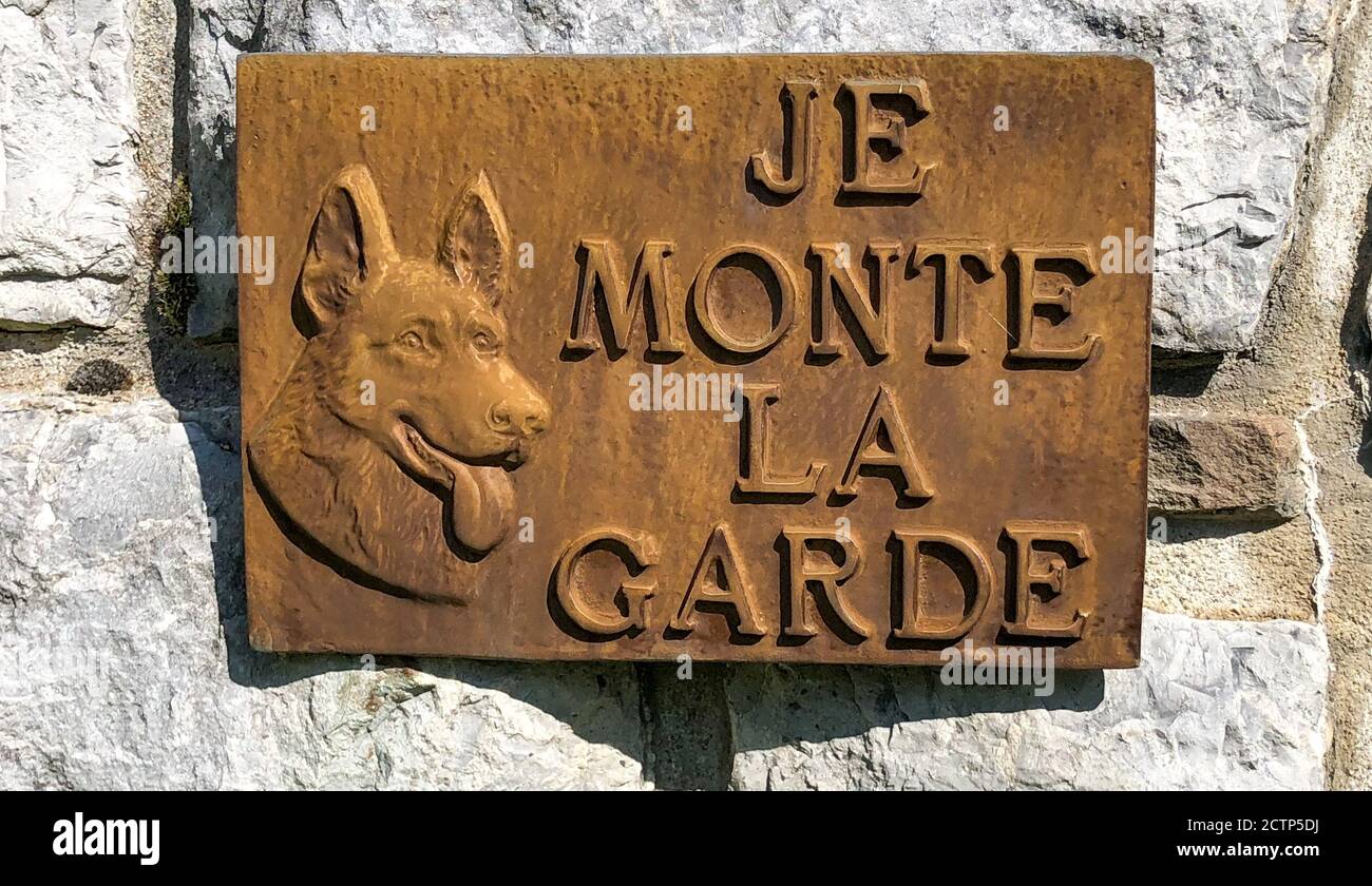 Das Bild eines Hundes auf einem Metallschild sagt: 'Je monte la Garde' oder 'Ich stehe Wache'. Stockfoto