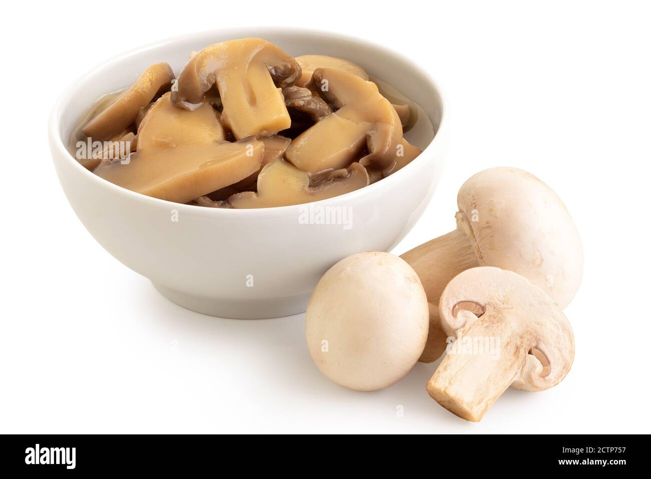 In Dosen geschnittene Champignons in einer weißen Keramikschale neben frischen Champignons, die auf Weiß isoliert sind. Stockfoto