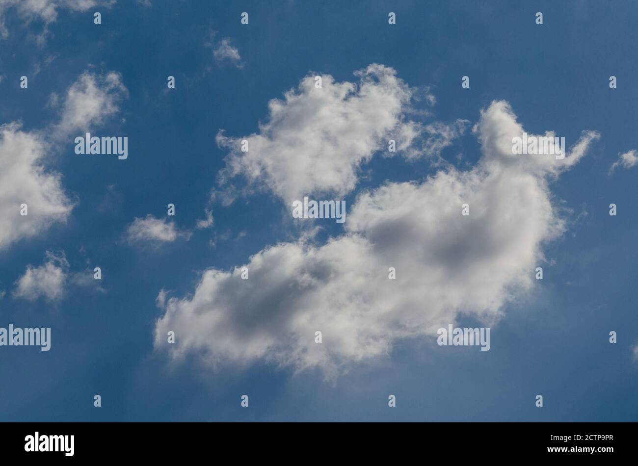 Flauschige Wolken in einem blauen Himmel Hintergrund und Muster Stockfoto
