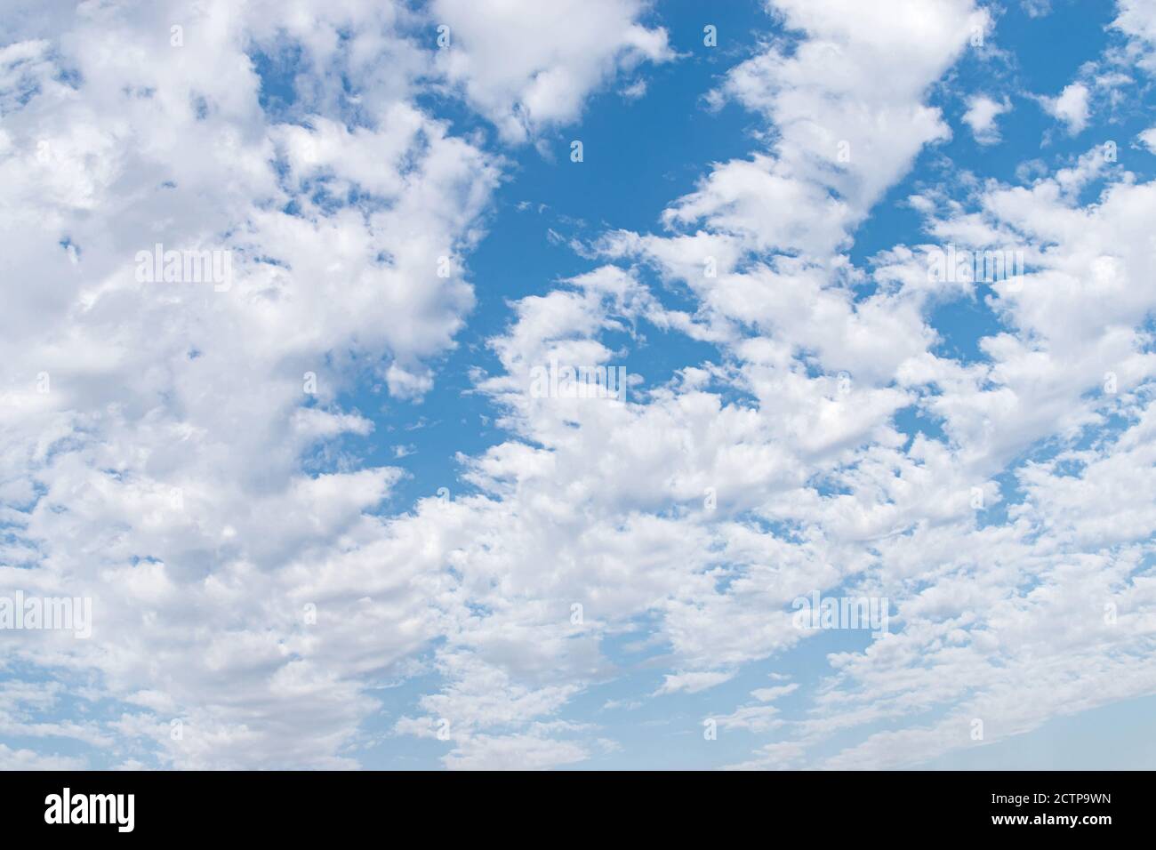 Weiße flauschige Wolken in einem blauen Himmel, Hintergrund und Muster Stockfoto