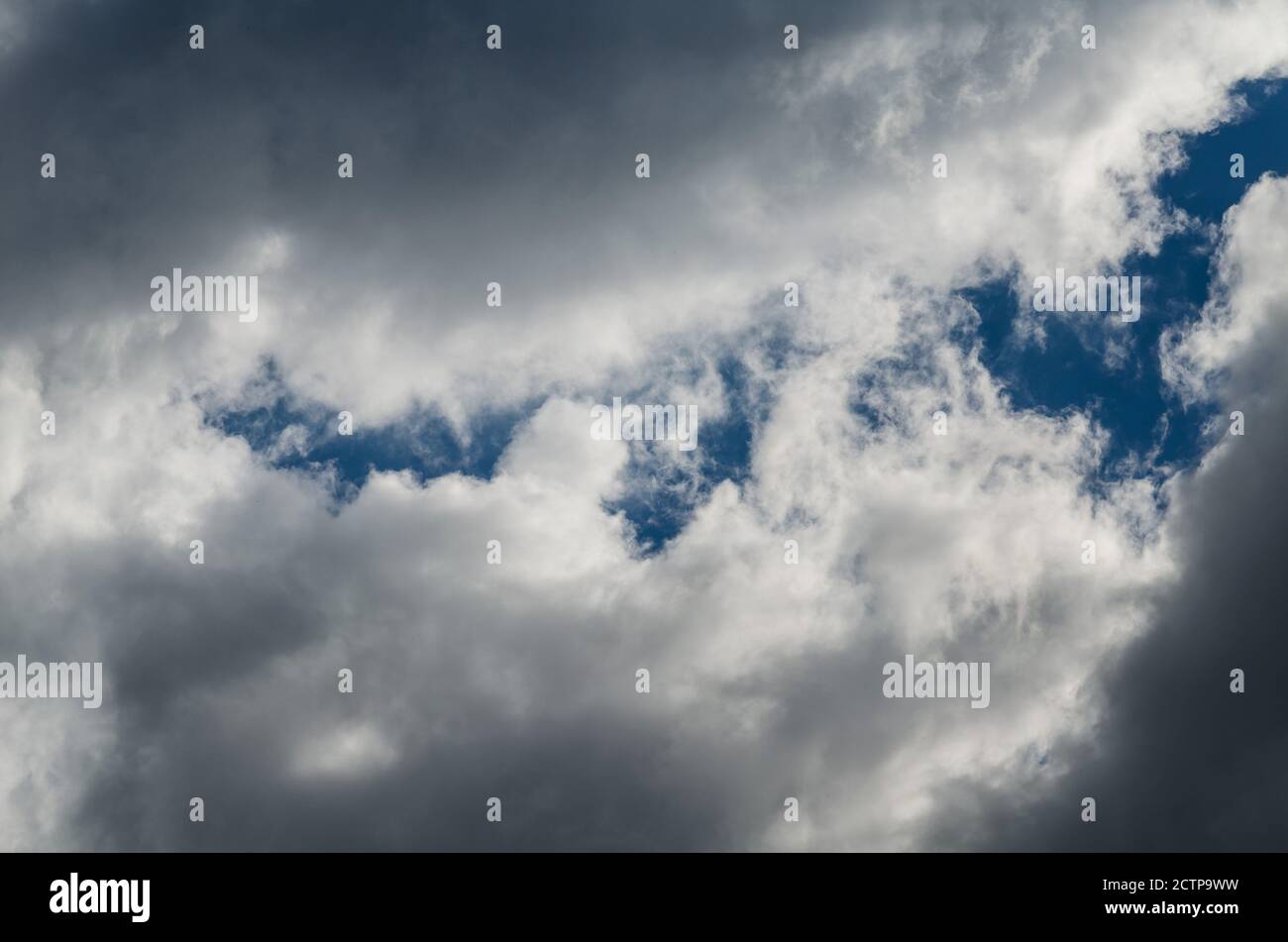 Sturm Wolken in einem blauen Himmel mit einer Lücke Stockfoto