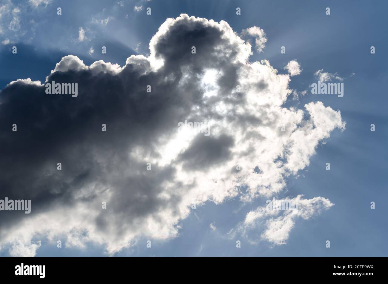 Sturmwolke auf einem blauen Himmel in den Strahlen der Die Sonne Stockfoto