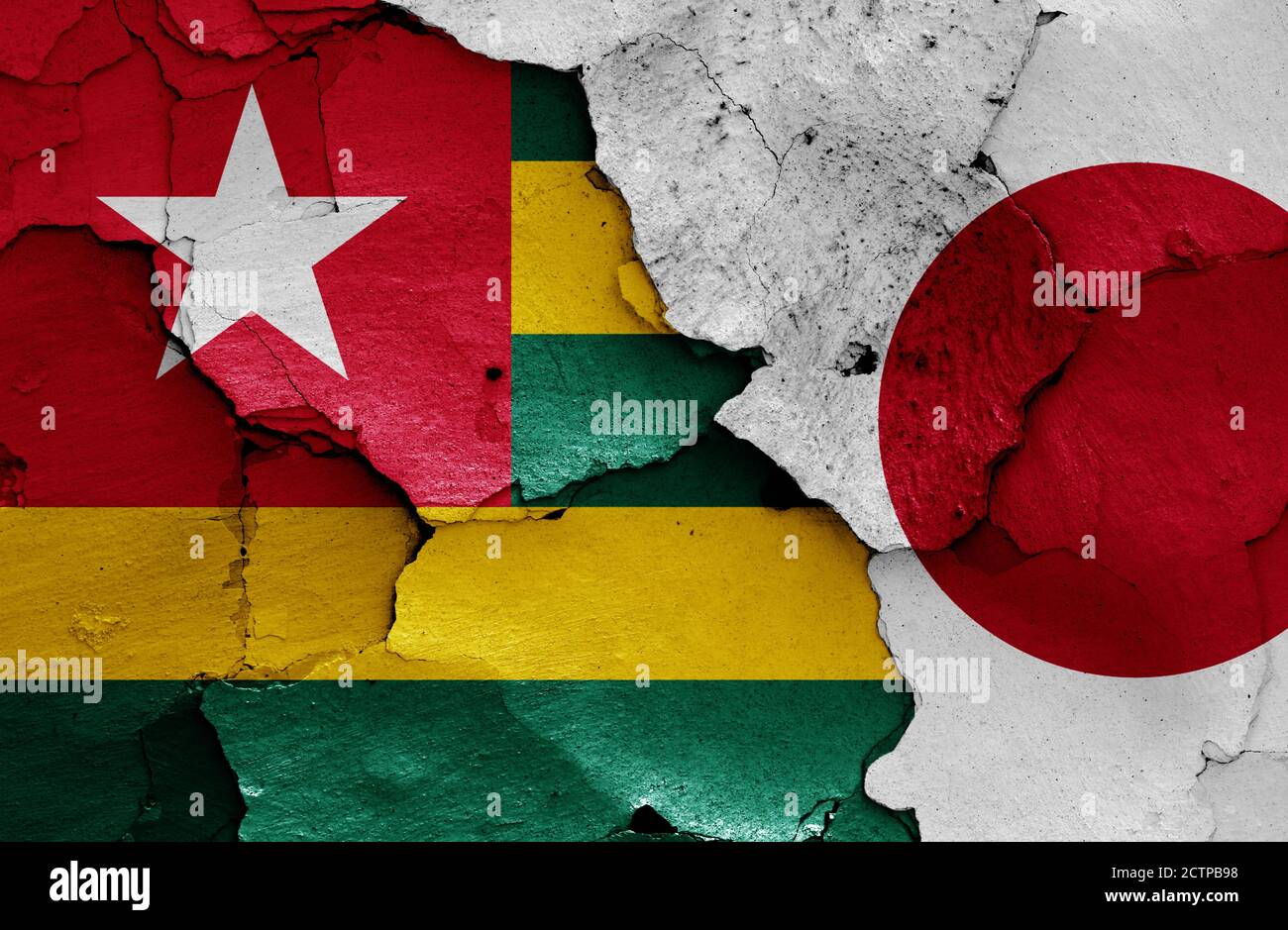 Flaggen von Togo und Japan auf rissige Wand gemalt Stockfoto
