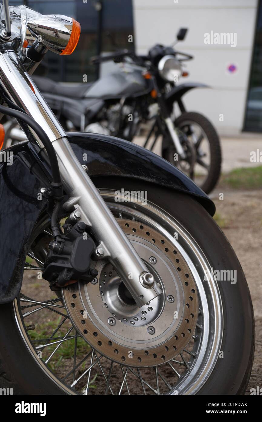 Blick auf zwei Motorräder, im Vordergrund Vorderrad, Bremsen und Stoßdämpfer. Stockfoto