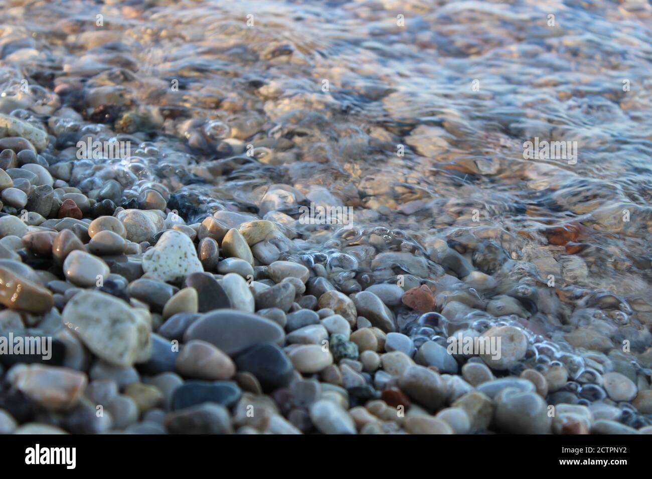 Kleine Steine, die vom Wasser benetzt werden Stockfoto