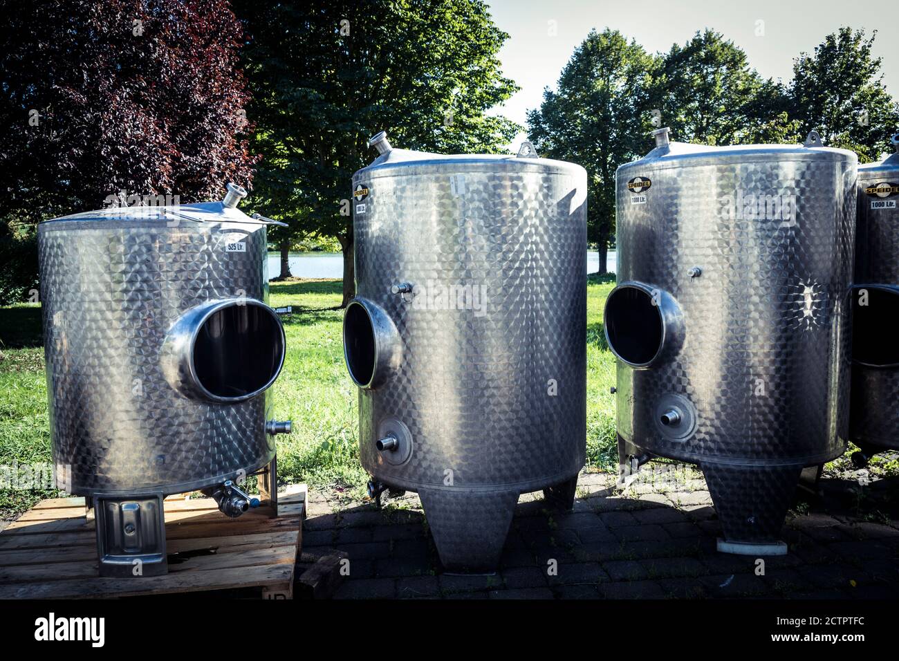 Edelstahltanks für die Weinproduktion leuchten im Sommer Sonnenschein, während sie auf die Installation warten, Piesport, Deutschland. Stockfoto