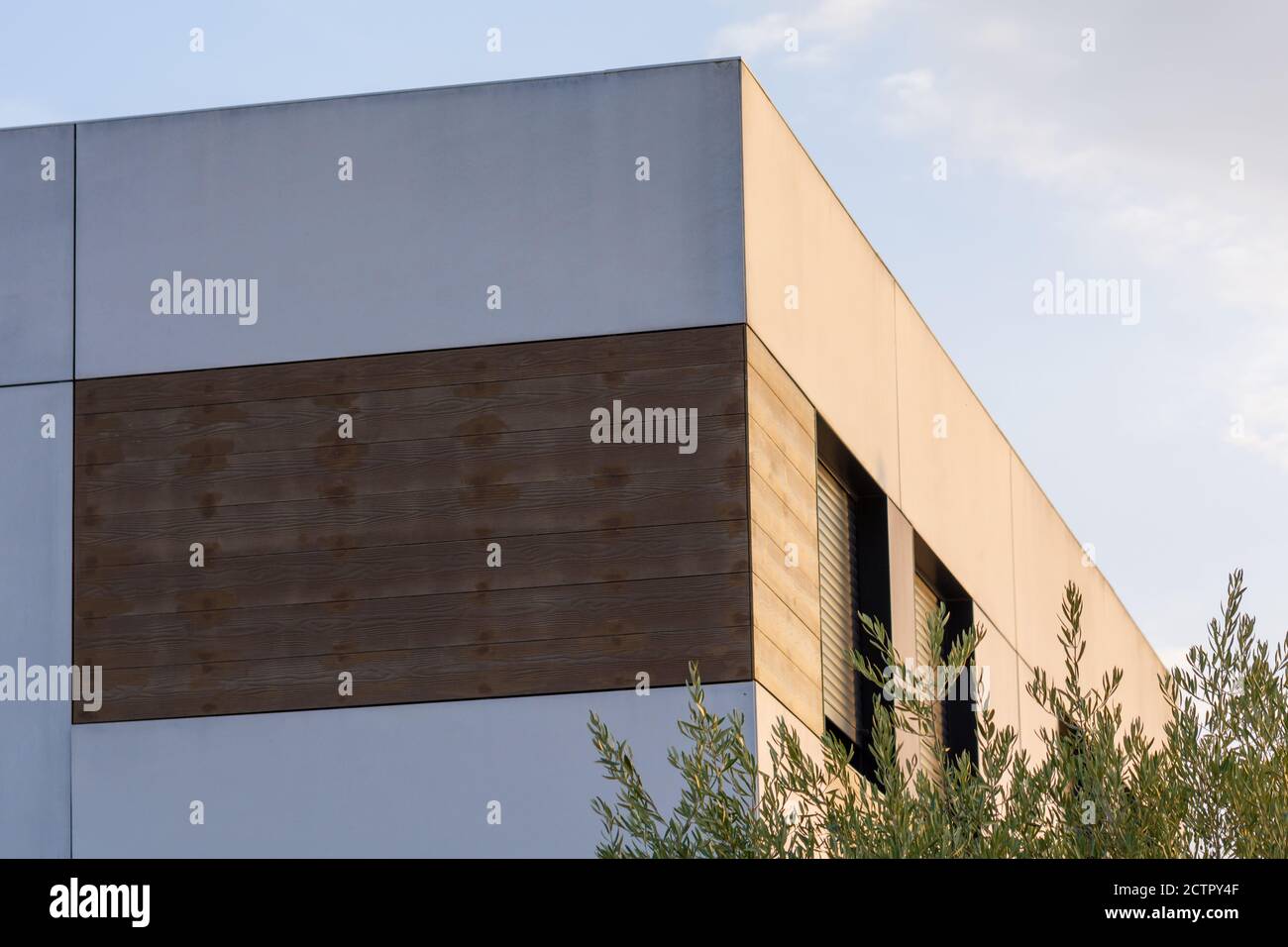 Fassade eines modernen Hauses mit Holzbrettern und Fenstern Mit Fensterläden bei Sonnenuntergang Stockfoto