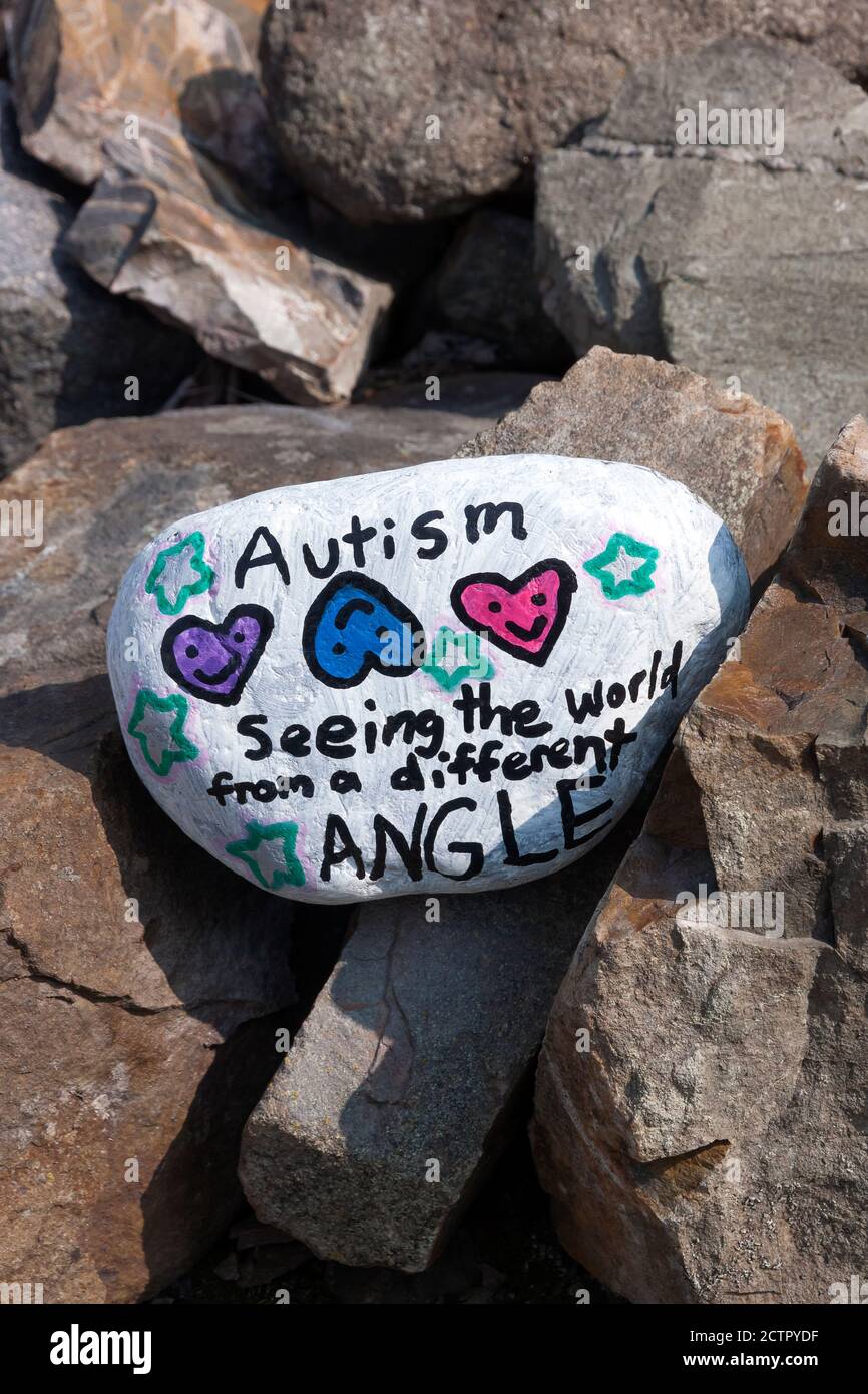 Bemalter Rock mit inspirierender Botschaft über Autismus. Stockfoto