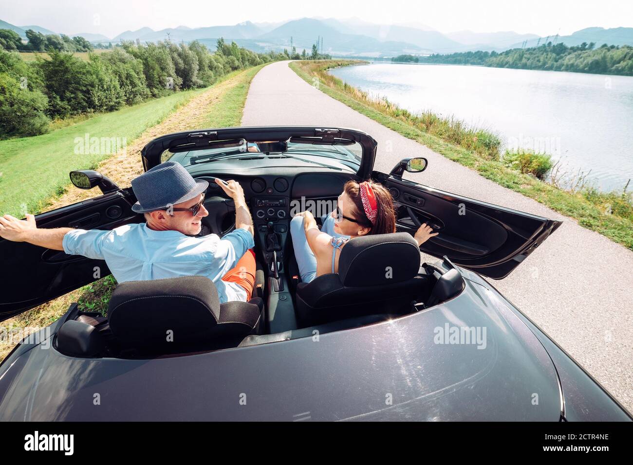 Ein Paar in der Liebe immer in das Cabrio-Auto und beginnt eine Reise. Paar Flitterwochen oder Urlaub Konzept Bild. Stockfoto