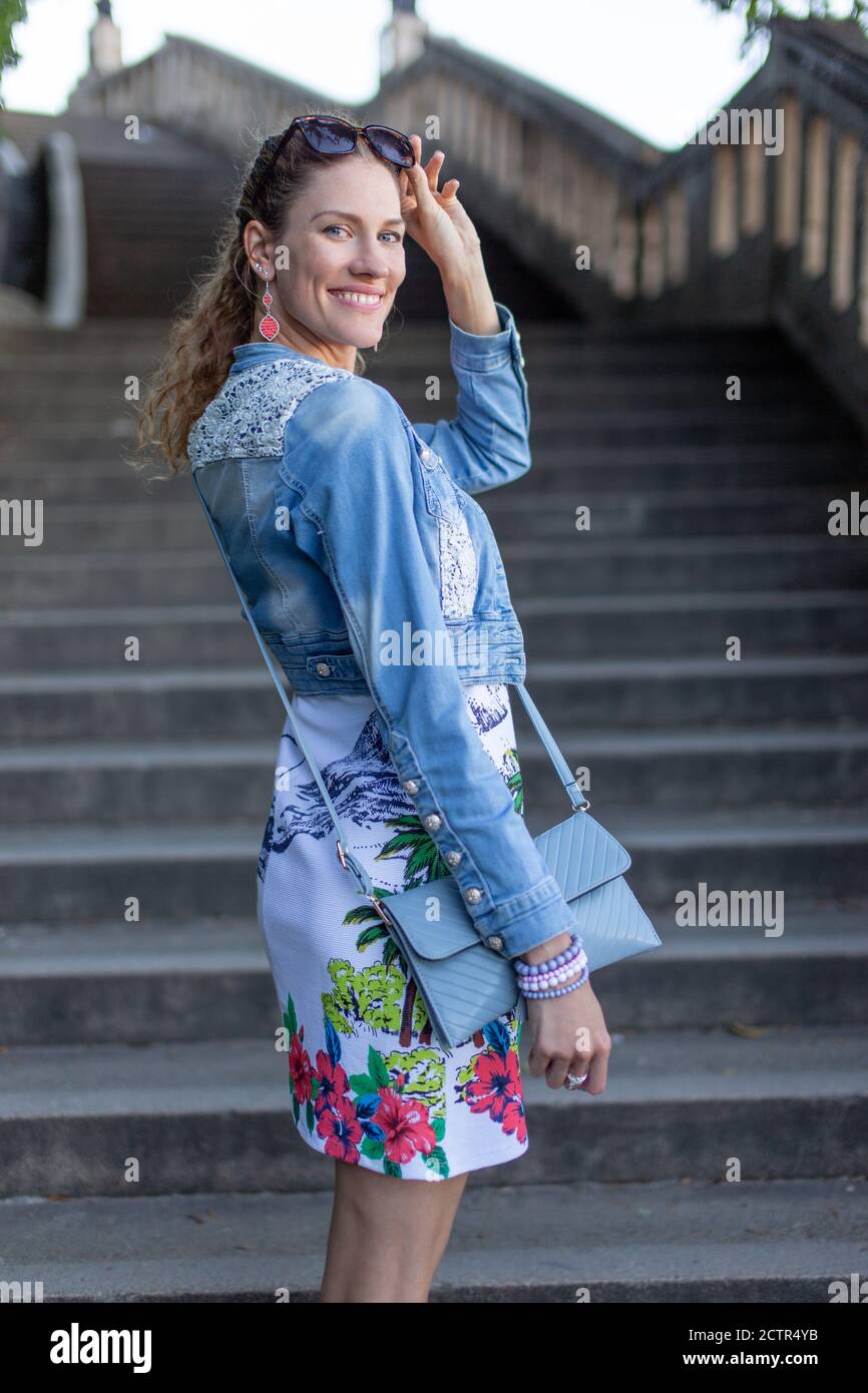 Glückliche junge kaukasische Stadtfrau Blick zurück auf Treppen in parken Stockfoto