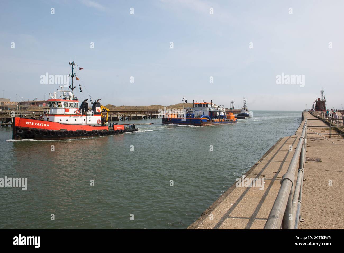 Gorleston, Norfolk, Großbritannien, 13-082020, Schlepper geathered zu Baggeroperationen Boot kommt in den Hafen Stockfoto
