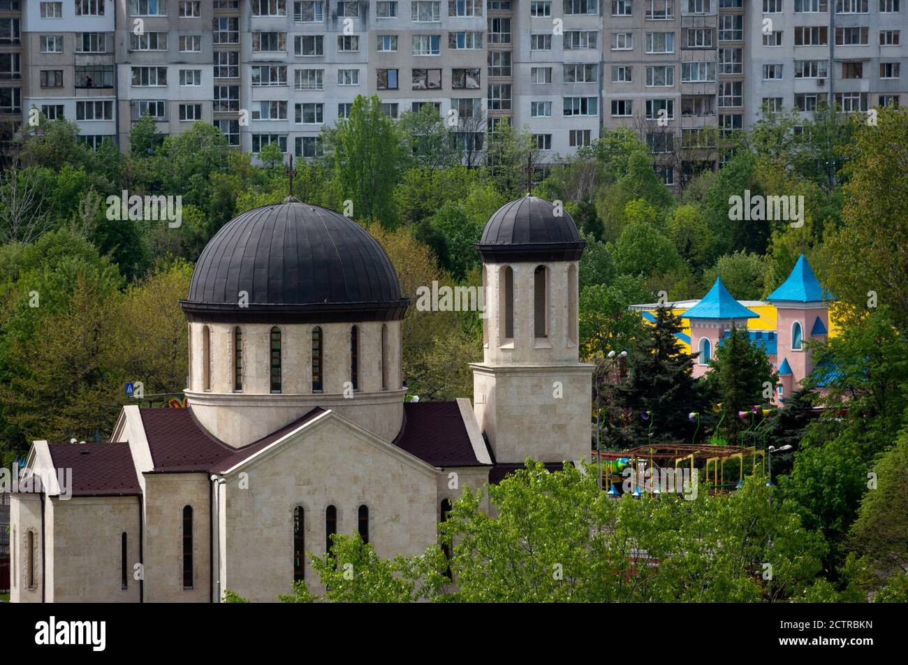 Stadtblick über den Park mit moderner Kirche und farbenfrohem Messegelände, umgeben von Bäumen als urbanisierende Nebeneinanderstellung, Sofia, Bulgarien Stockfoto