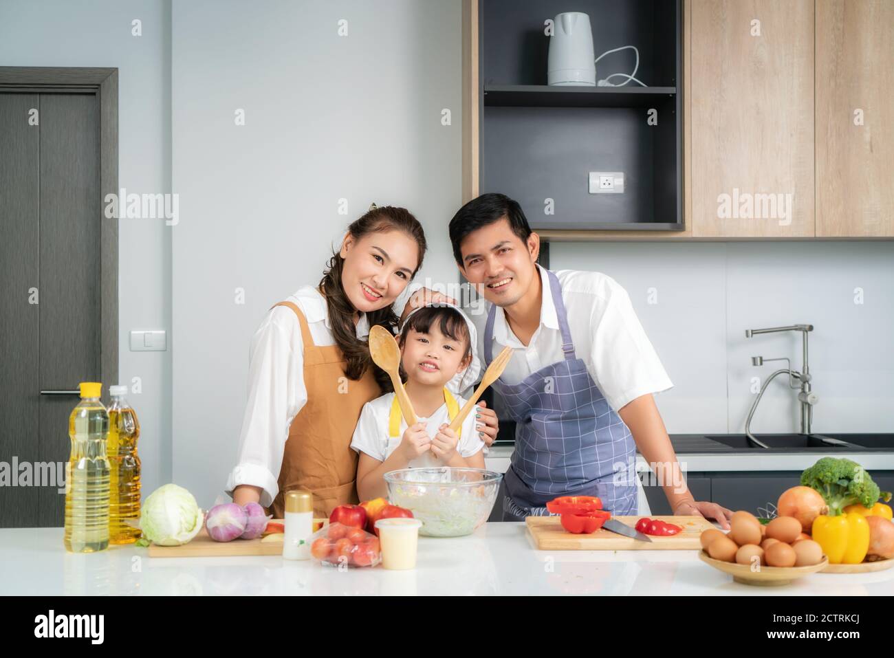 Junge asiatische Liebe Familie bereiten Salat Gemüse auf dem Tisch In der Küche, die Vater und Mutter lehren Tochter Kochen Essen am Tag um Stockfoto