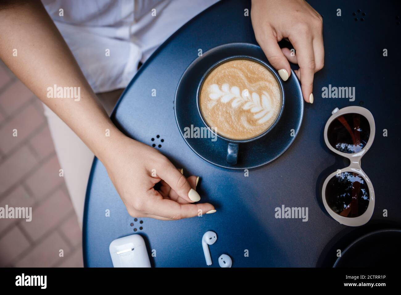 Tasse Cappuccino mit einem Muster auf einer Holzbank. Stockfoto