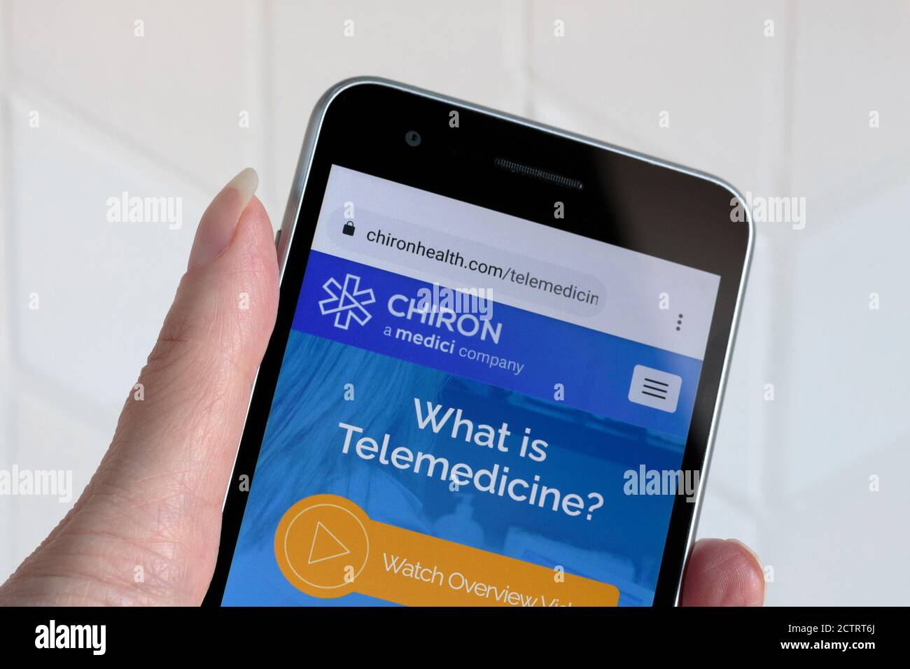 Smartphone in der Hand einer Person mit dem Bildschirm gehalten Auf der mobilen Telemedizin-App von Chiron Health Stockfoto