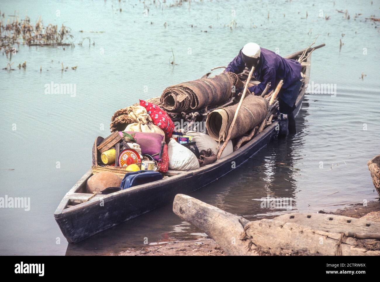 Tacherane, Mali, am Niger. Ein Mann, der sein Boot vorbereitet, um nach einem Tag auf dem Markt nach Hause zu fahren. Stockfoto