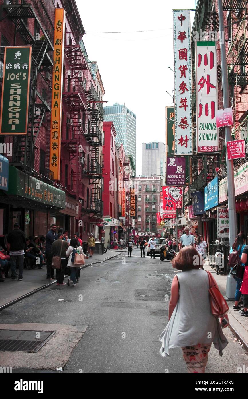 Frau geht an einem Frühlingsnachmittag in Chinatown, NYC, die Straße hinunter Stockfoto