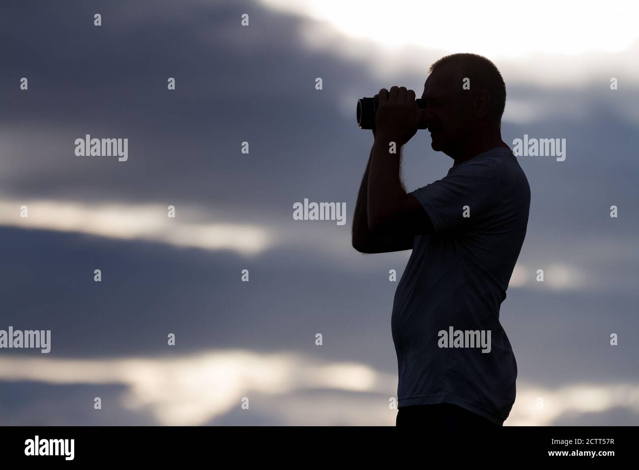 Ein Mann in Silhouette mit einem Fernglas Stockfoto