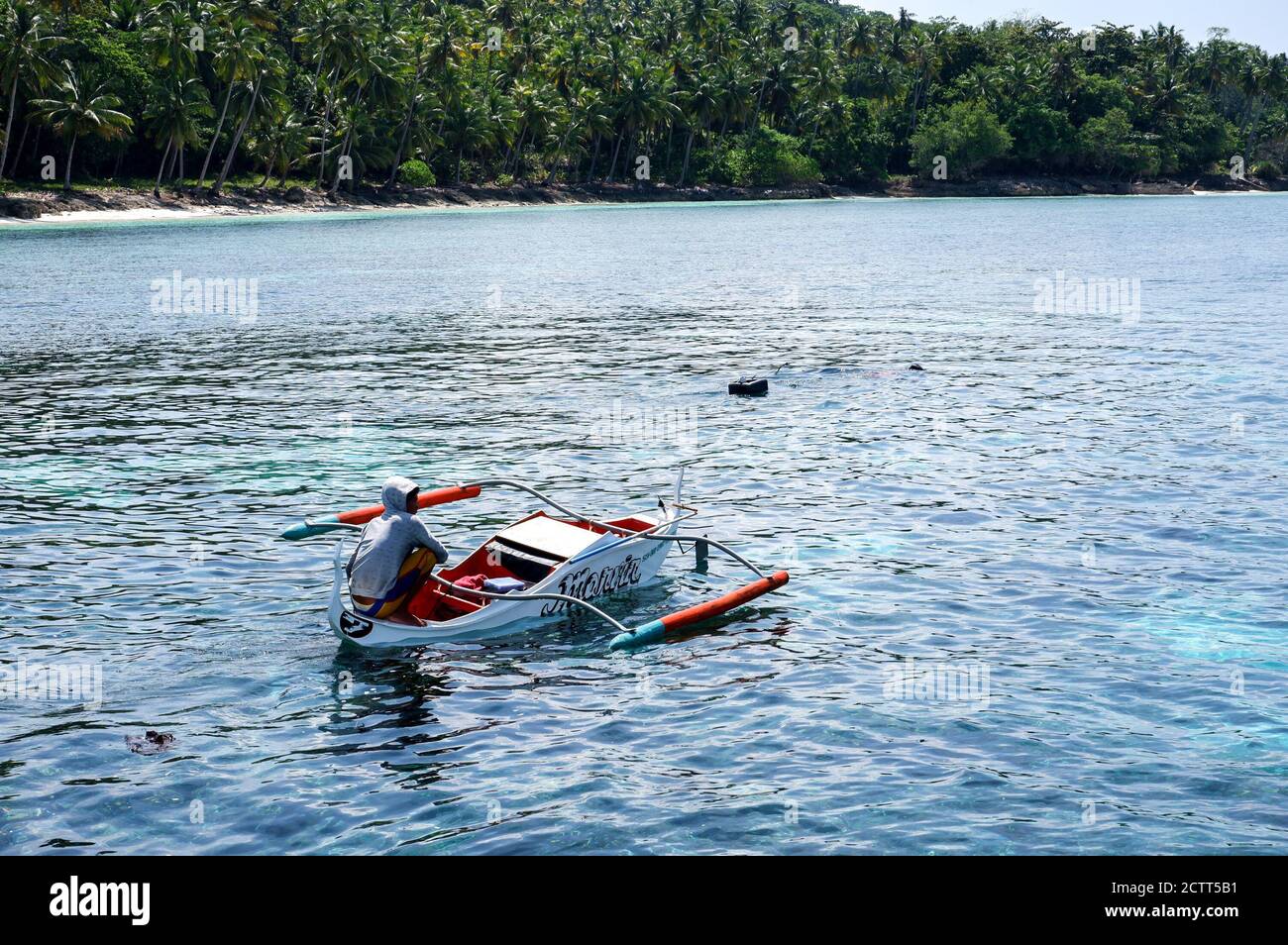 Junger Mann auf einem kleinen Boot in der Mitte von Das Meer Stockfoto