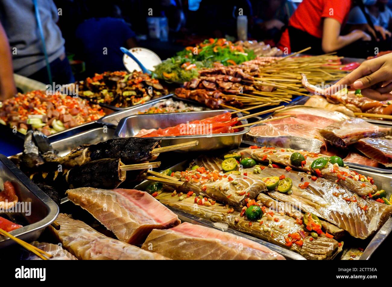 Verschiedene Fisch- und Fleischgerichte auf dem Nachtmarkt Stockfoto