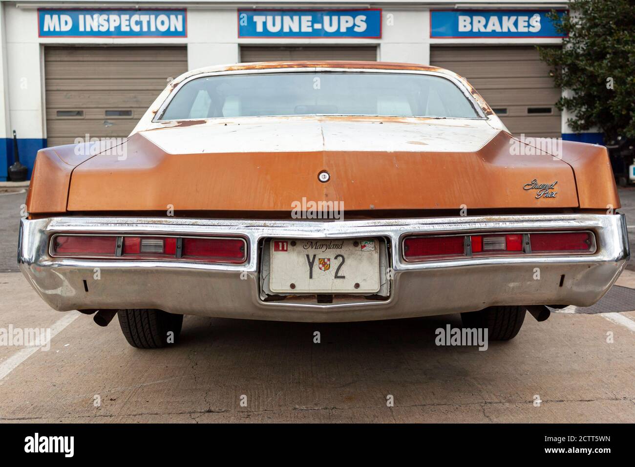 Rockville, MD, USA 09/12/2020: Rückansicht des alten orangenen rostigen Pontiac Grand Prix, der vor einer Mechaniker-Werkstatt geparkt ist. Dies ist eine dritte Generation (1972 Stockfoto