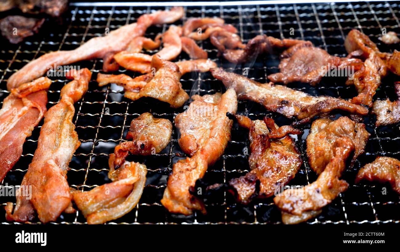 Holzkohlegrill von marinierten Schweinestreifen mit Raucheffekt Stockfoto