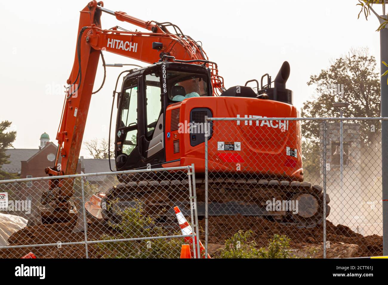 Bethesda, MD, USA 09/12/2020: Blick auf eine Baustelle, während die Arbeitsmaschinen arbeiten. Das Bild zeigt einen roten Hitachi Bagger dahinter Stockfoto