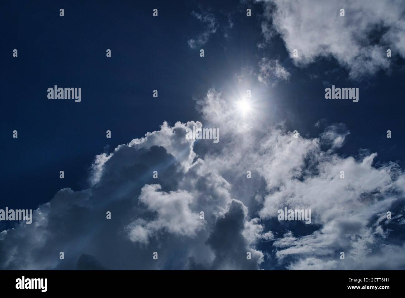 Weiße Wolken und Sonne am blauen Himmel Stockfoto