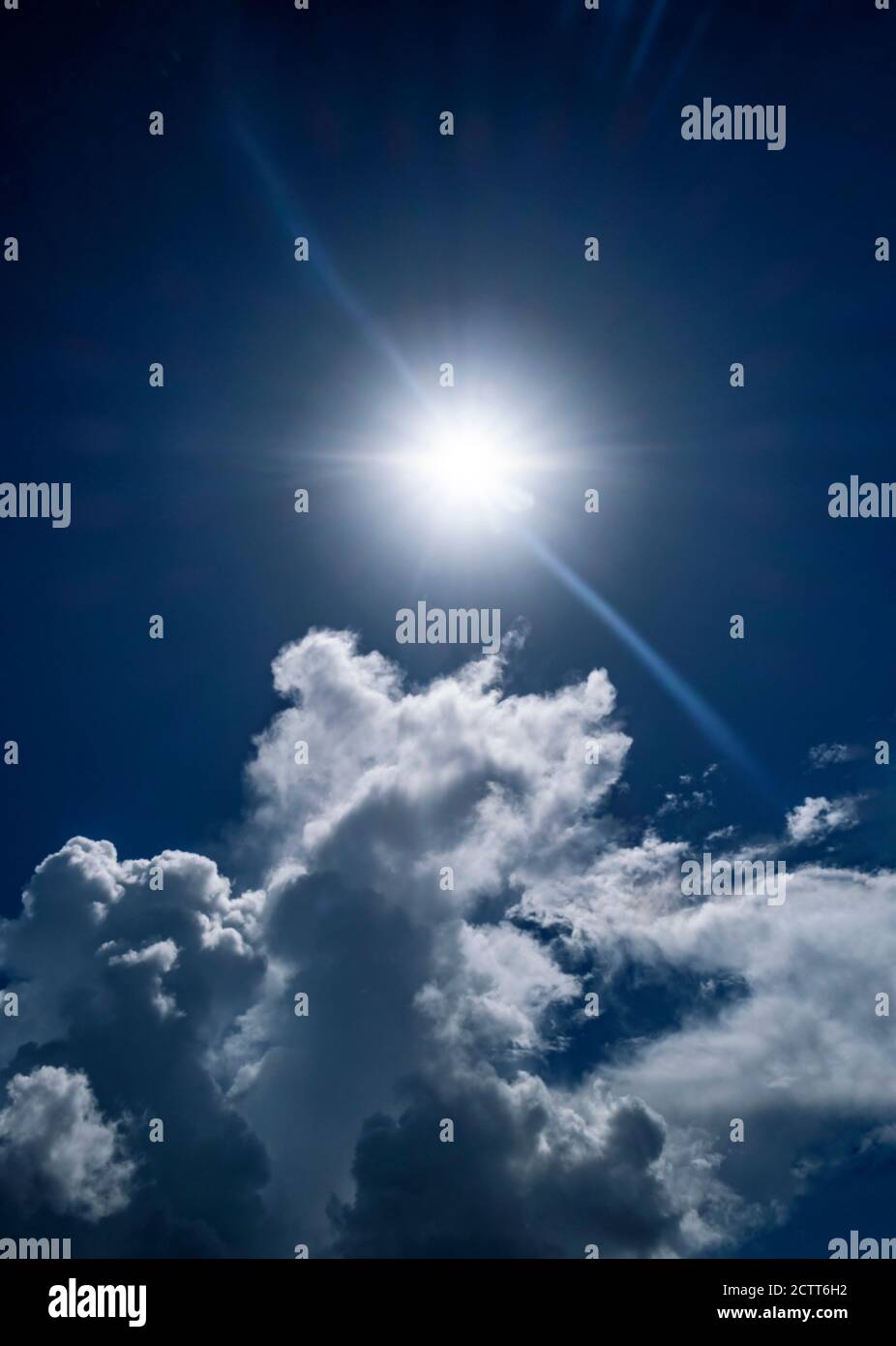 Weiße Wolken und Sonne am blauen Himmel Stockfoto