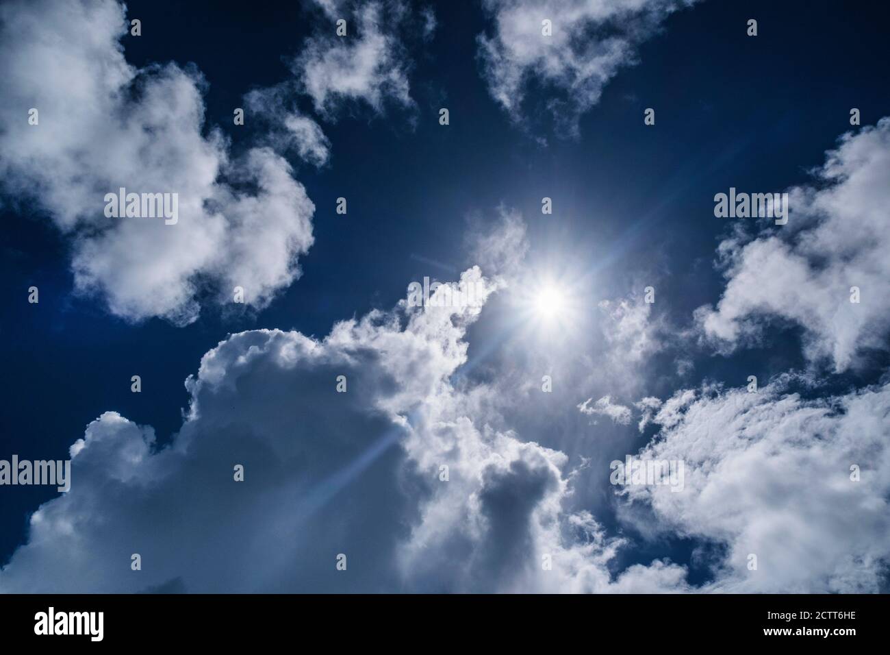 Weiße Wolken und Sonne am blauen Himmel Stockfoto