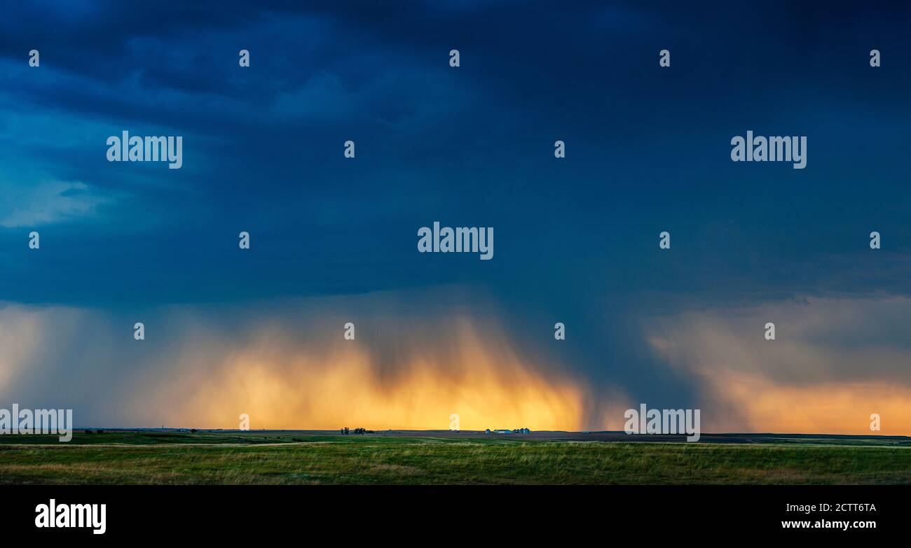 USA, South Dakota, Sonne bricht durch Sturmwolken und Regen bei Sonnenuntergang Stockfoto