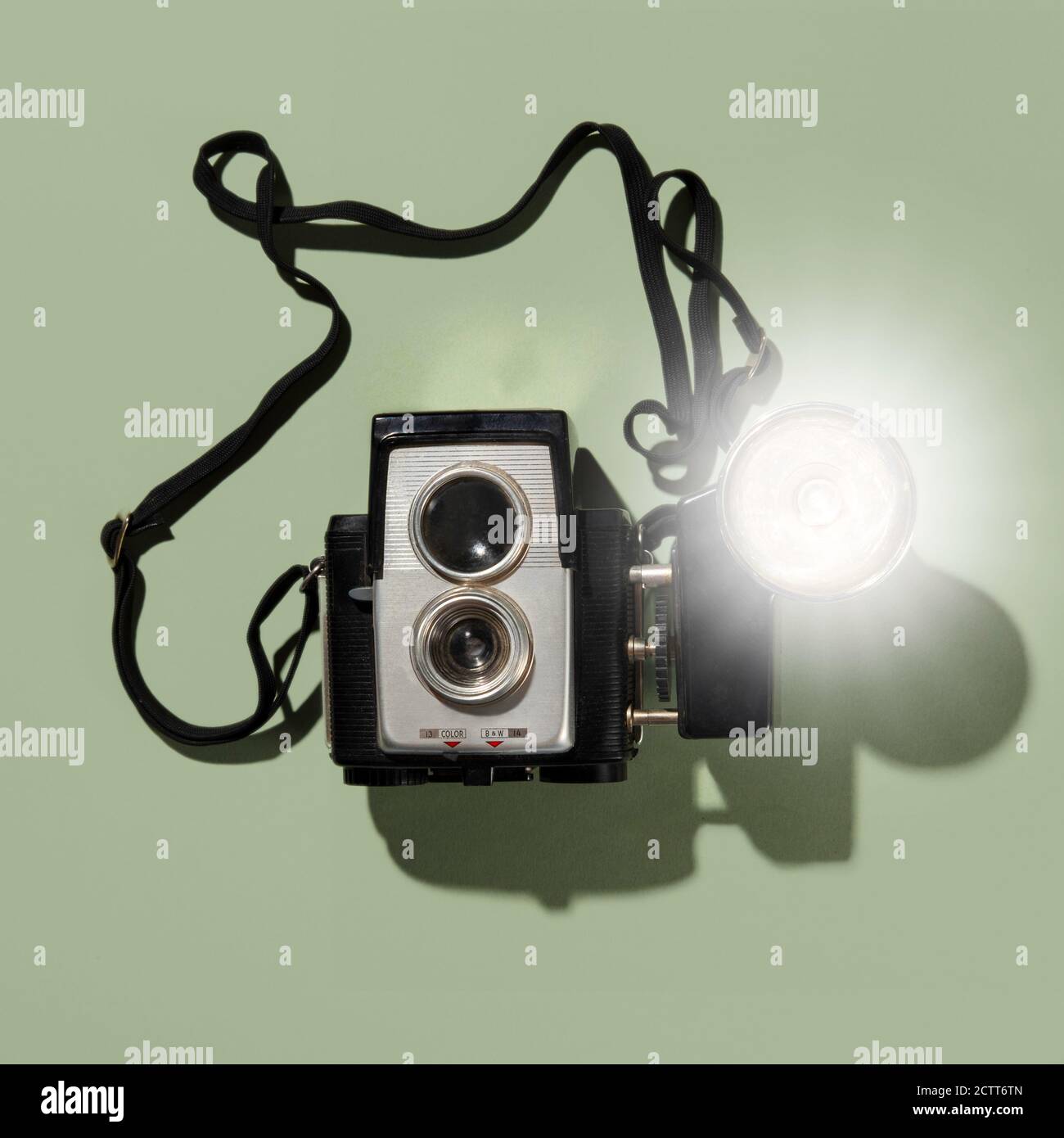 Retro-Kamera mit blub Blitz auf grünem Hintergrund Stockfoto