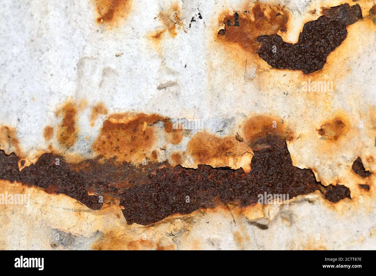 Rostig abblätternde, weiße Metallhintergrundwand mit Rostflecken. Stockfoto