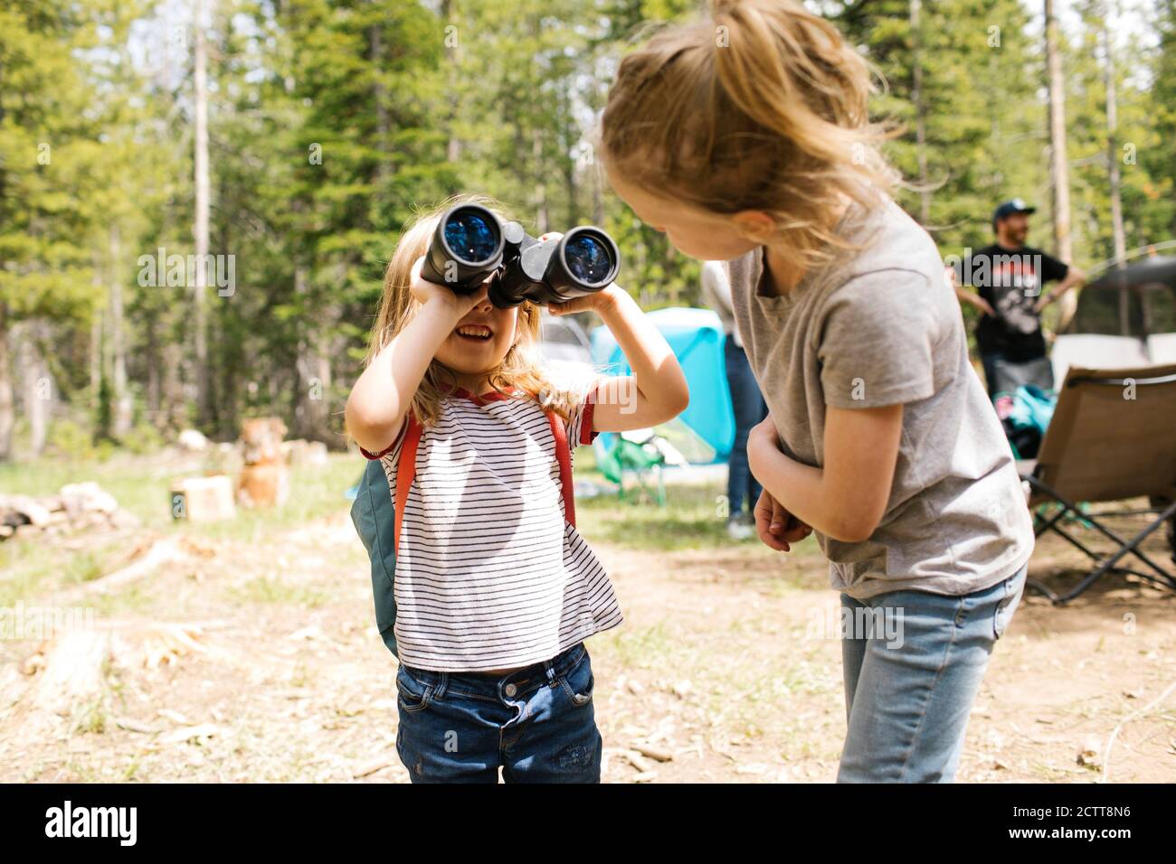 Mädchen (4-5, 6-7) spielen mit dem Fernglas auf Camping im Wald, Wasatch-Cache National Forest Stockfoto