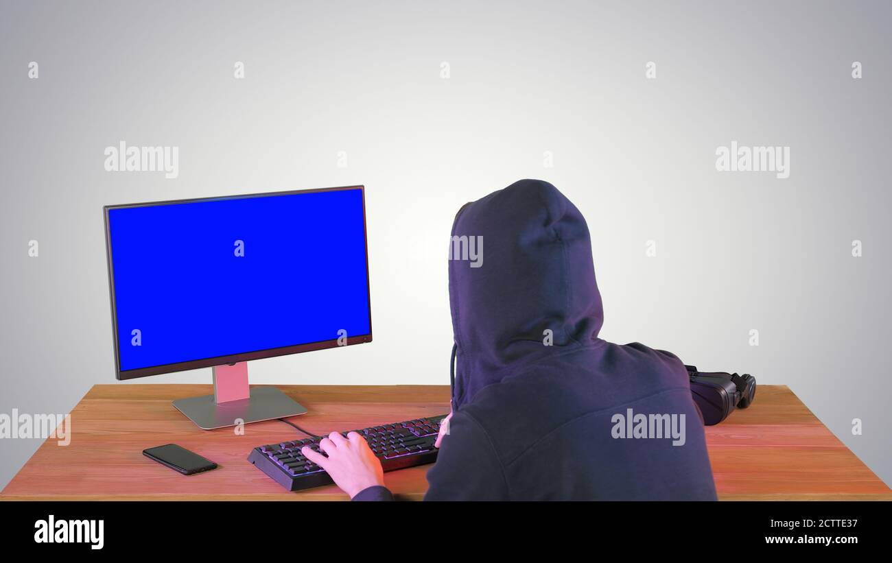 Hacker in Hood Cracking-Code mit pc auf Gradienten Hintergrund. Stockfoto