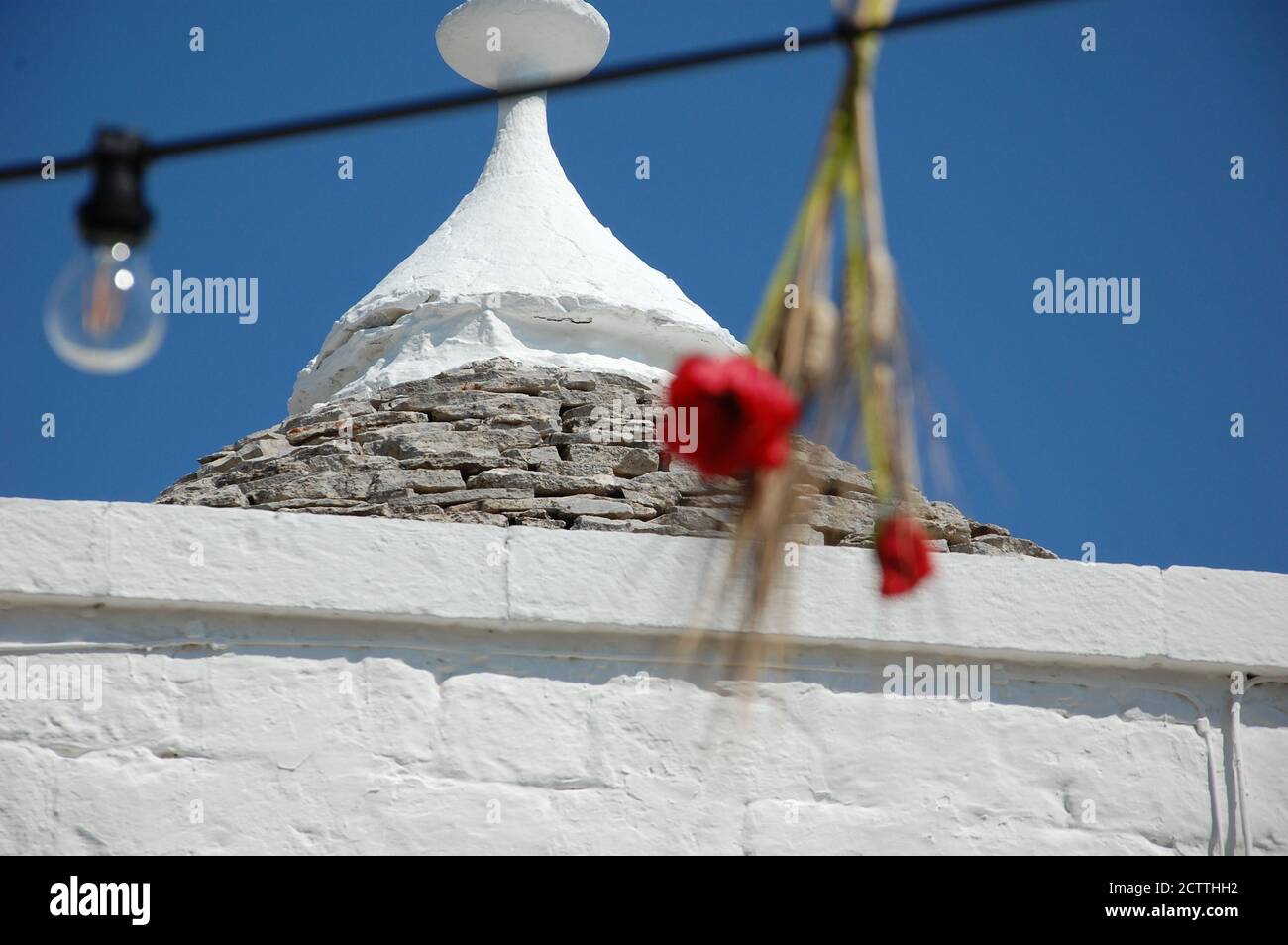Straßendekoration Details im Vordergrund und die Oberseite eines Stein kegelförmigen Dach eines Trullo-Haus im Hintergrund in Alberobello UNESCO-Stätte Stockfoto