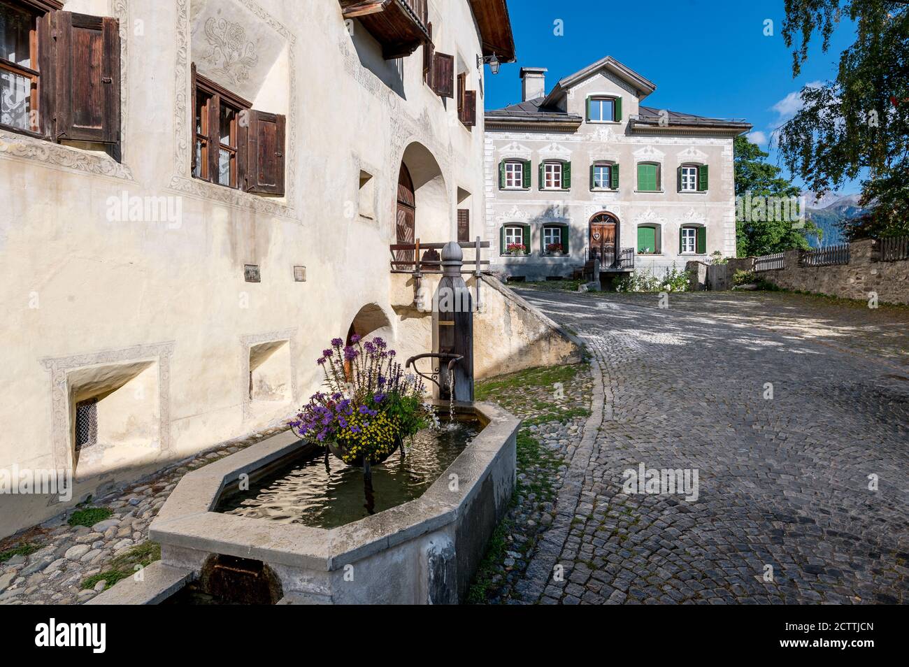 Schöne Engadinerhäuser in Guarda mit Brunnen Stockfoto