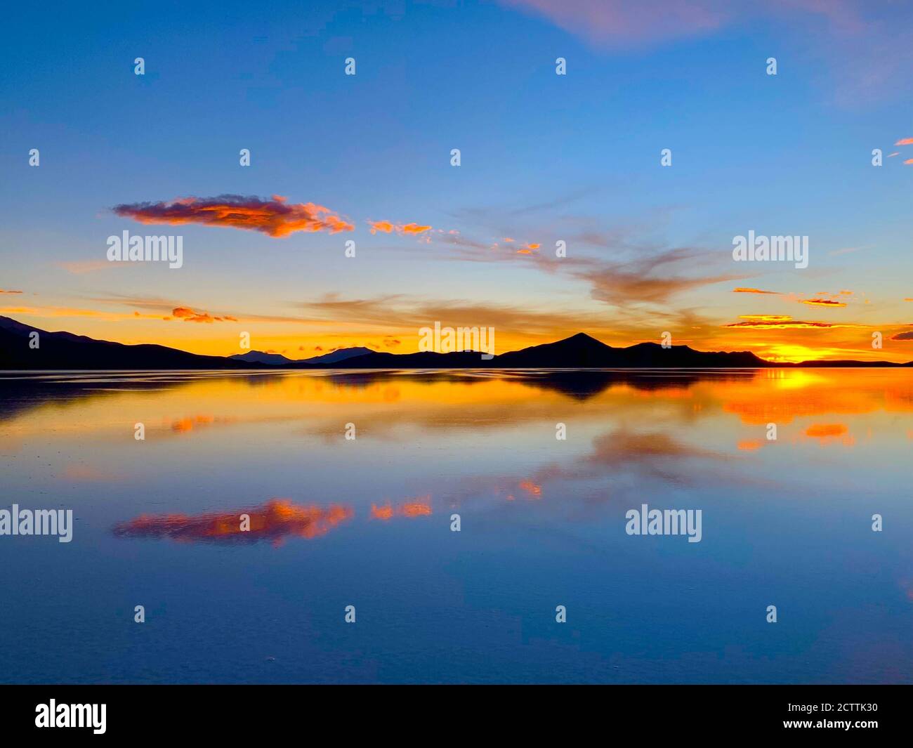 Spektakuläre Sonnenuntergangsspiegelung im Salzwasser. Dramatischer Sonnenuntergang. Wüstensee Salar de Uyuni. Farbiger Himmel. Wunderschöne Sonnenuntergänge in den bolivianischen Anden Stockfoto