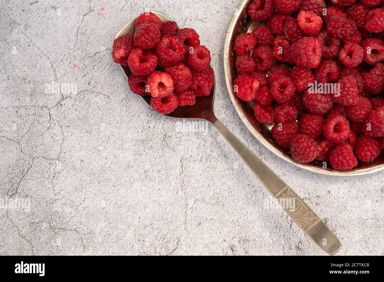 Frisch gepflückte Himbeeren auf grauem Hintergrund, gesunde Ernährung Konzept Stockfoto